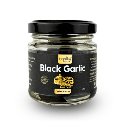 Jar of black garlic with a black lid on a white background
