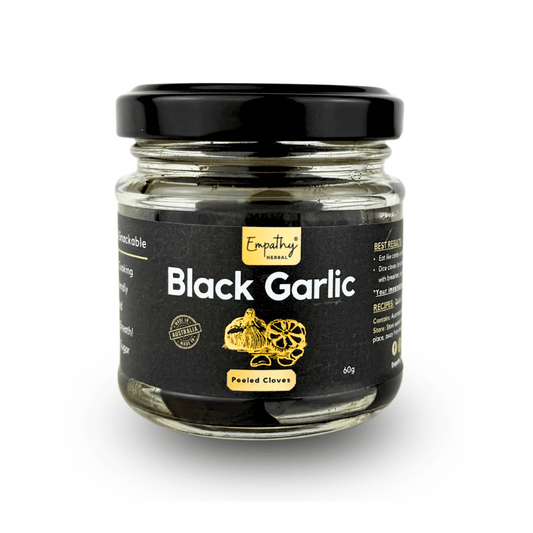 Jar of black garlic with a black lid on a white background